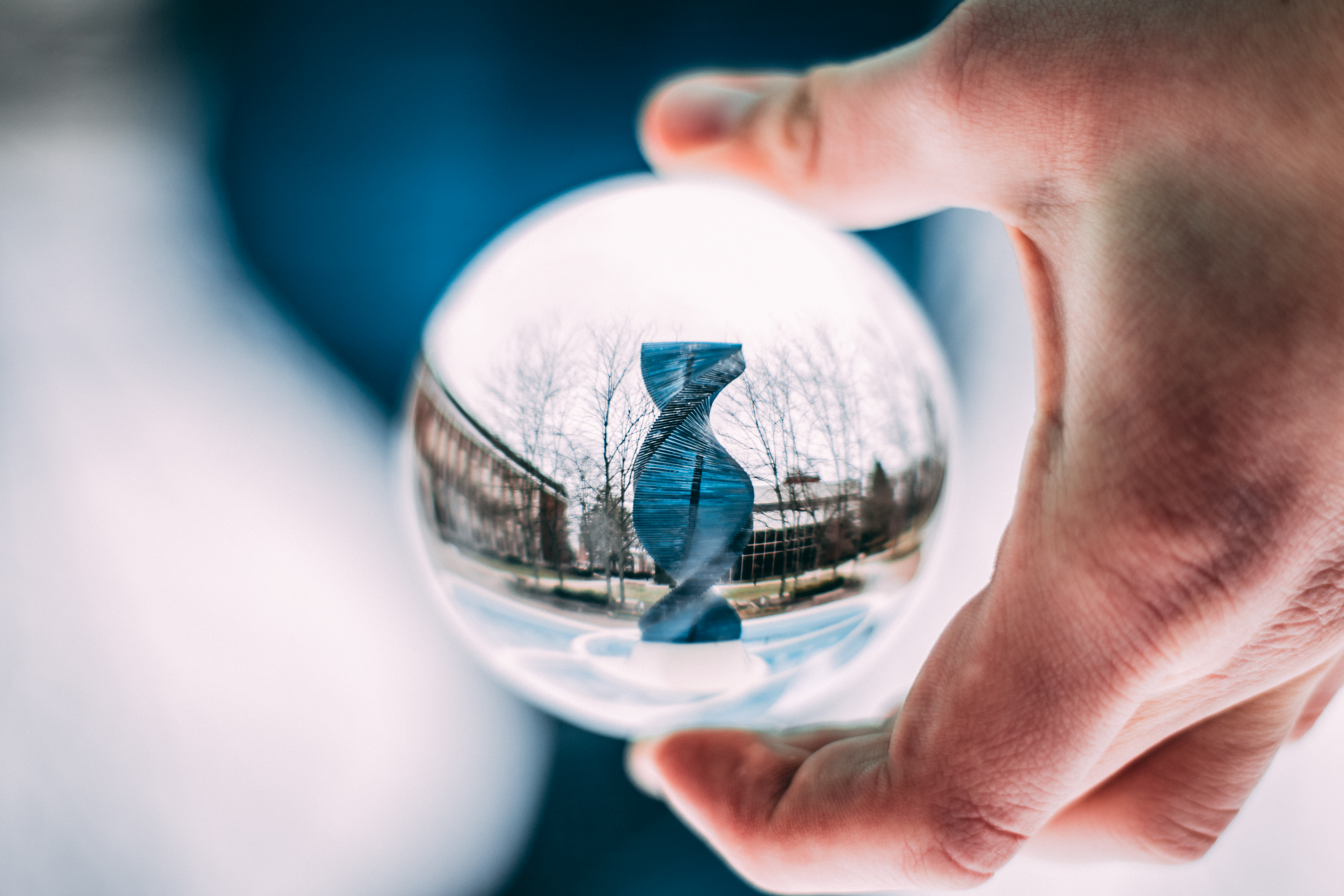 Canva - Person Holding Sphere Reflecting Dna-shaped Statue